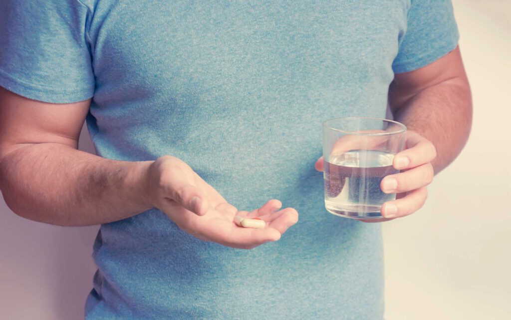 Man taking acetaminophen for his hernia recovery